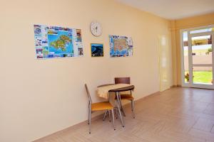 a room with a table and chairs and a clock on the wall at Despoina in Skiathos Town