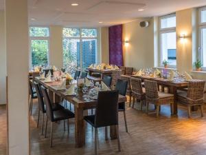 - une salle à manger avec des tables, des chaises et des fenêtres dans l'établissement Haus Müllestumpe, à Bonn