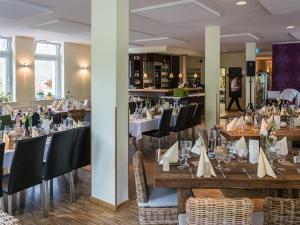 une salle à manger avec des tables et des chaises ainsi qu'un restaurant dans l'établissement Haus Müllestumpe, à Bonn