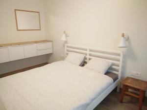 um quarto com 2 camas brancas e um espelho em Juodrakantė & Neringa apartment em Juodkrantė