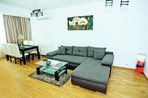 a living room with a couch and a table at Monaco Grand Apartments By CityBookings in Bucharest