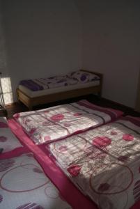 2 Betten in einem Zimmer mit rosa Rosen drauf in der Unterkunft Apartmán Český ráj in Turnov