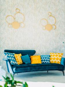 um sofá azul com almofadas coloridas contra uma parede em Mare e marmellata em Ravenna