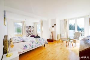 a white bedroom with a bed and a table and chairs at Aux Premières Loges in Fécamp
