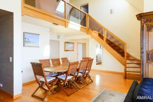 a dining room with a table and chairs and a staircase at Aux Premières Loges in Fécamp
