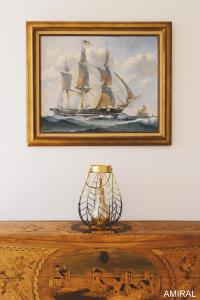 a painting of a ship on a table with a lamp at Aux Premières Loges in Fécamp