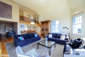 a living room with blue couches and a table at Aux Premières Loges in Fécamp