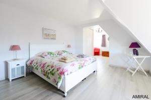 a white bedroom with a bed and a desk at Aux Premières Loges in Fécamp