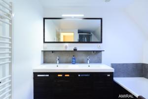 a bathroom with a sink and a mirror at Aux Premières Loges in Fécamp