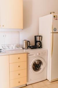 a kitchen with a washing machine and a refrigerator at Best House, Nirvana II, Patra in Patra