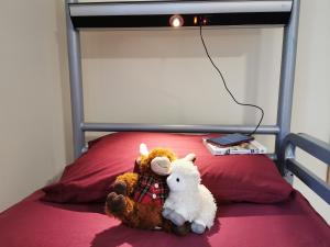 a teddy bear sitting on top of a bed at Morag's Lodge in Fort Augustus