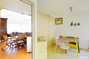 a kitchen and dining room with a table and chairs at Aux Premières Loges in Fécamp