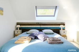 a bedroom with a blue bed with towels on it at Aux Premières Loges in Fécamp