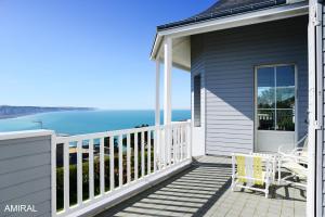 a house with a balcony with a view of the ocean at Aux Premières Loges in Fécamp