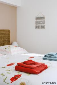 a red towel sitting on top of a bed at Aux Premières Loges in Fécamp