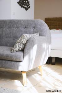 a gray couch with a pillow on it next to a bed at Aux Premières Loges in Fécamp