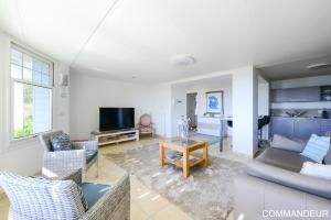 a living room with a couch and a tv at Aux Premières Loges in Fécamp