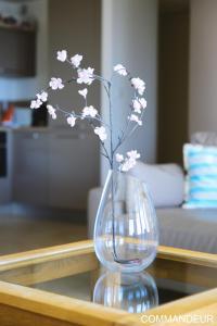 a glass vase with flowers in it on a table at Aux Premières Loges in Fécamp