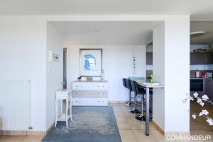 a kitchen with white walls and a blue rug at Aux Premières Loges in Fécamp