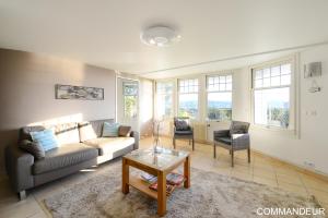 a living room with a couch and a table at Aux Premières Loges in Fécamp