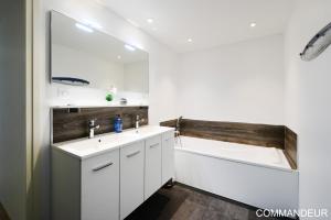 a bathroom with two sinks and a bath tub at Aux Premières Loges in Fécamp
