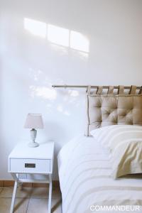 a white bedroom with a bed and a white nightstand at Aux Premières Loges in Fécamp