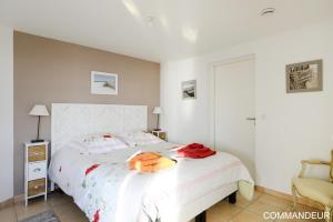 a bedroom with a white bed with an orange bag on it at Aux Premières Loges in Fécamp