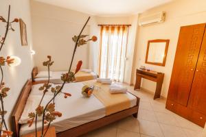 a hotel room with two beds and a mirror at Villa Morfeas in Paralia Katerinis