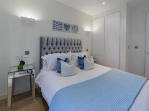 a bedroom with a large white bed with blue pillows at Exclusive Tower Bridge Apartment in London