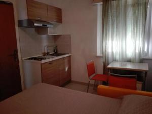 a small kitchen with a sink and a table at New Prophet Appartamenti in Cattolica
