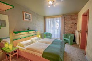 een slaapkamer met een groot bed en 2 stoelen bij Hotel Ulftaler Schenke in Burg-Reuland