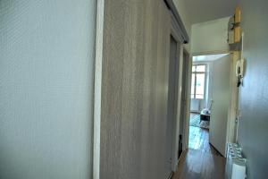 een hal met een witte muur en een hal met een deur bij Apart city in Montargis