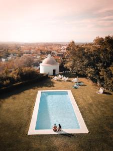 two people sitting in a swimming pool on a hill at Conimbriga Hotel do Paço in Condeixa a Nova