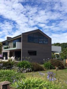 a house with glass windows in a garden at The Hamptons in Kaikoura
