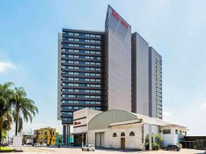 a tall building with a car parked in front of it at ibis Santos Valongo in Santos