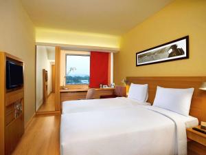 A bed or beds in a room at ibis Hyderabad Hitec City - An Accor Brand