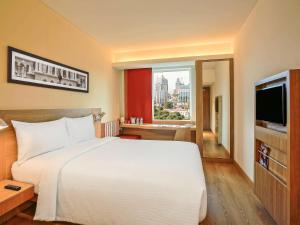 a bedroom with a large white bed and a window at ibis Kochi City Centre - An Accor Brand in Cochin