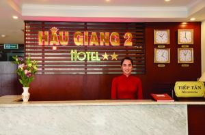 una mujer sentada detrás de un mostrador en un restaurante en Hau Giang 2 Hotel Cần Thơ, en Can Tho