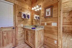 ein Bad mit einer Blockhütte und einem Waschbecken in einem Zimmer in der Unterkunft Heavenly Bear, Hot Tub, FREE Attraction tickets for each paid day, Pool Table, WIFI!!! in Sevierville + 47 Fotos