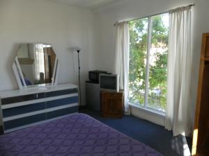 ロサンゼルスにあるウィルシャー オレンジ ホテルのベッドルーム(紫色のベッド1台、窓付)
