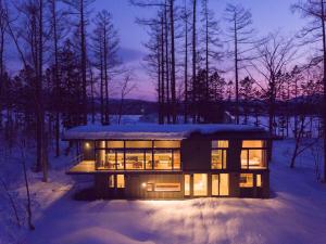 a house in the woods at night in the snow at Hiyoku 飛翼 in Niseko