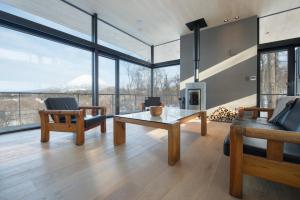a living room with a table and a fireplace at Hiyoku 飛翼 in Niseko +18 photos