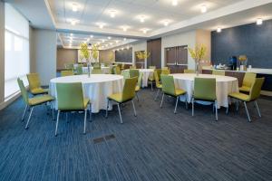 a conference room with white tables and yellow chairs at Holiday Inn Express & Suites - Murrieta by IHG in Murrieta