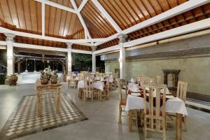 a restaurant with tables and chairs in a building at Nipuri Resort and Villas Seminyak by Kamara in Seminyak