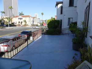 a sidewalk with cars parked on the side of a street at Wilshire Orange Hotel in Los Angeles