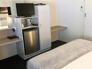a hotel room with a tv and a refrigerator at Balonne River Motor Inn in Saint George