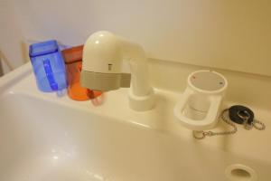 a sink with a blow dryer and other items on it at Kyo Fushimi inari house in Kyoto