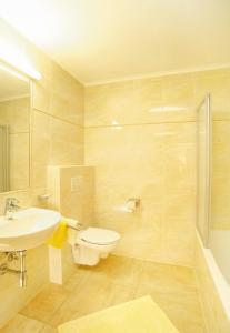 ein Bad mit einem Waschbecken, einem WC und einer Dusche in der Unterkunft Hotel Tirolerhof in Sankt Anton am Arlberg