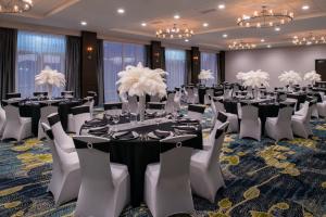 uma sala de banquetes com mesas, cadeiras e lustres em Holiday Inn & Suites - Farmington Hills - Detroit NW, an IHG Hotel em Farmington Hills