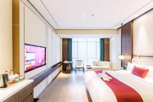 een hotelkamer met een groot bed en een televisie bij Days Hotel by Wyndham Binjiang Changsha in Changsha